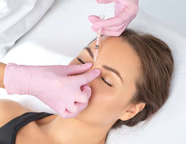 Cosmetologist makes rejuvenating anti wrinkle injections on the face